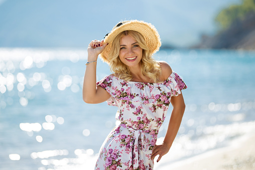 Mujer joven en la playa con vestido de sol photo