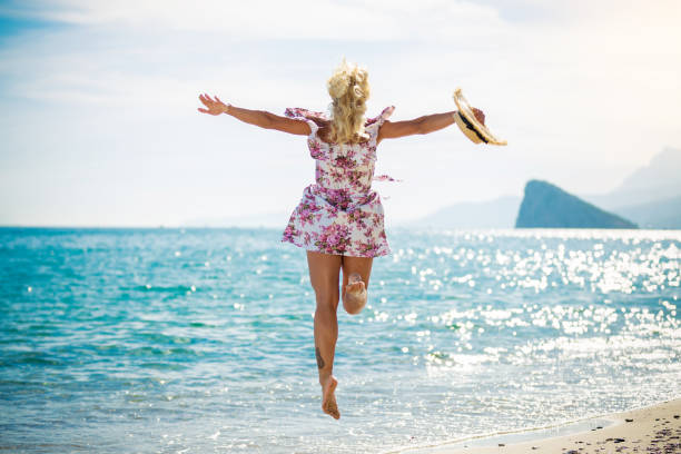 istock Young woman jumping on the beach 1081873702