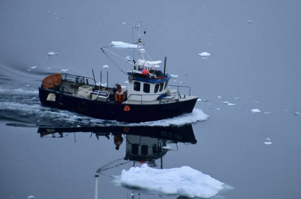istock Fishermen boat on sea with iceberg 1081876254