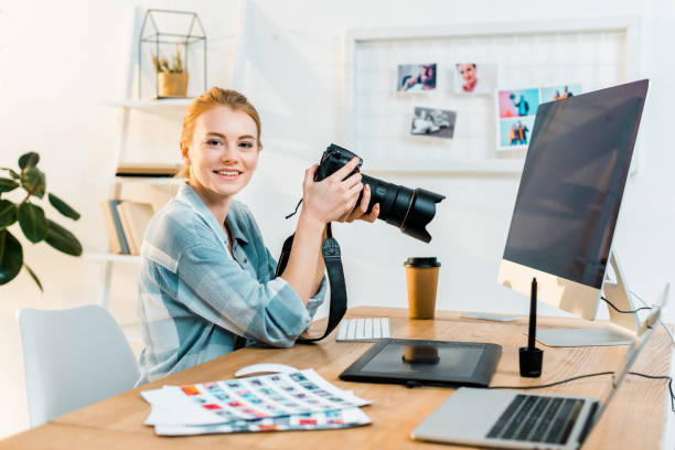 istock beautiful young female photographer smiling at camera while working in office 1081881242