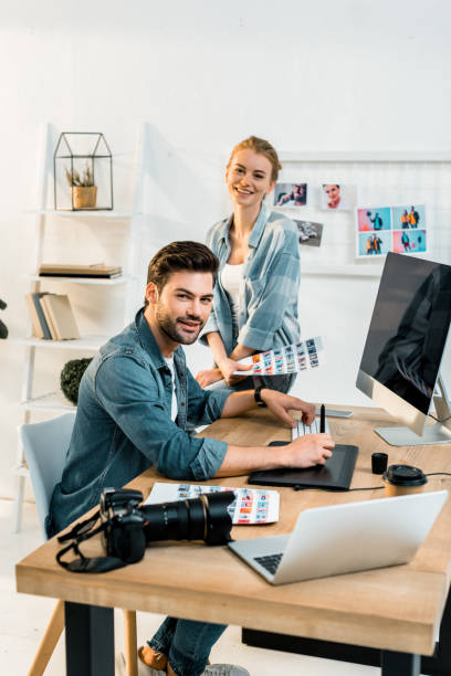 istock professional young photographers smiling at camera while retouching photos in office 1081881436