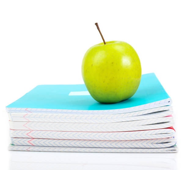 istock apple on writing-books. school concept 1081881644