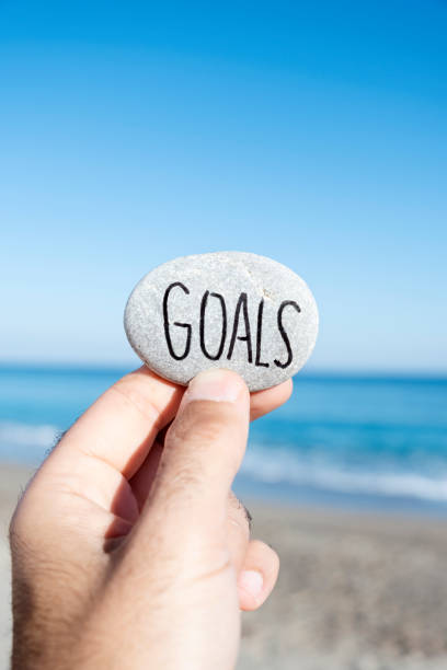 istock man holding a stone with the text goals 1081883552