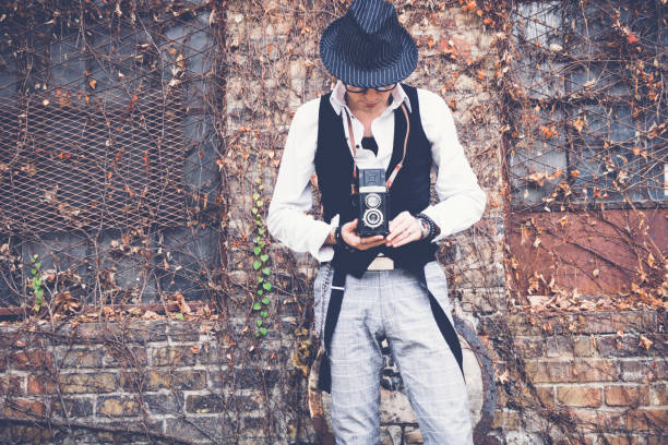istock Retro styled man taking picture with vintage photo camera. 1081887436