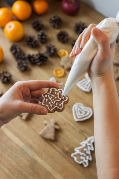 glacê de bolo de gengibre natal processo de decoração. biscoitos doces caseiros - baking cake making women - fotografias e filmes do acervo