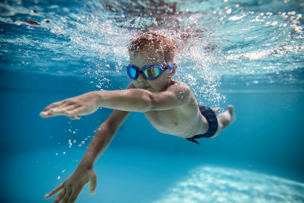 niño nadando crol en la piscina - child swimming pool swimming little boys fotografías e imágenes de stock