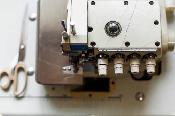 istock top view closeup details on sewing machine overlock. Workplace seamstress.Tailoring industry. 1081892962
