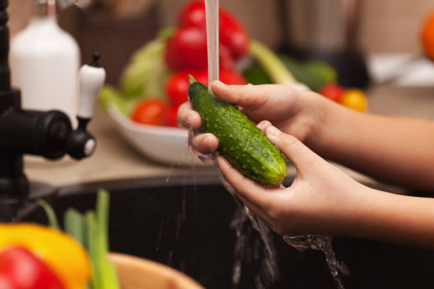 istock Child hands washing a cucumber at the sink, shallow depth 1081894568