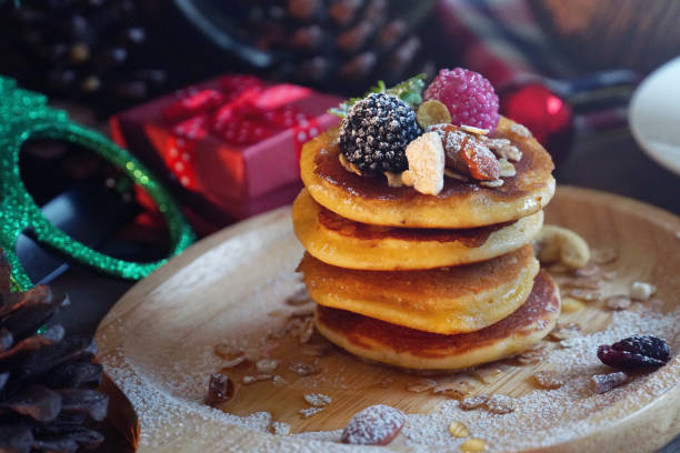 istock Pancake topping with berries and nut with background gift and pine cone under christmas tree, holiday party dessert 1081897358