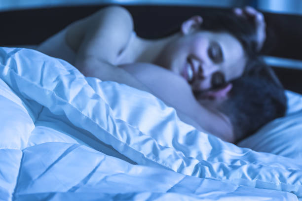 The happy man and woman lay on the bed. night time stock photo