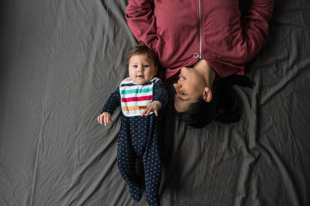 Mother and daughter View from above on a little girl and her mom lying on the bed mm21 stock pictures, royalty-free photos & images