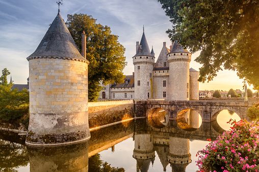 France - Sept 21, 2013: Castle or chateau of Sully-sur-Loire at sunset. This old castle is a famous landmark in France. Beautiful sunny view of the French castle on the water. Fairytale medieval castle in summer.