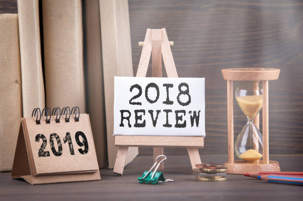 istock 2018 review concept. Sandglass, hourglass or egg timer on wooden table 1081911196