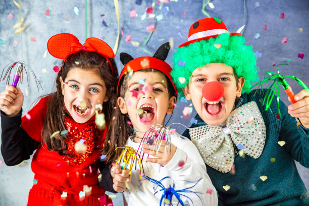 trois enfants célèbrent ensemble les carnaval à la maison - costume de scène photos et images de collection