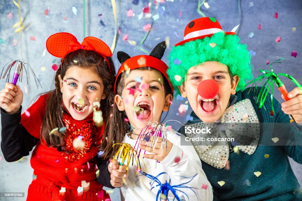 Three kids celebrating Carnival  together at home Carnival - Celebration Event Stock Photo