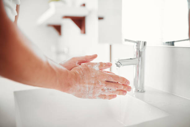 using an anti germ handwash - washing hands hygiene human hand faucet imagens e fotografias de stock