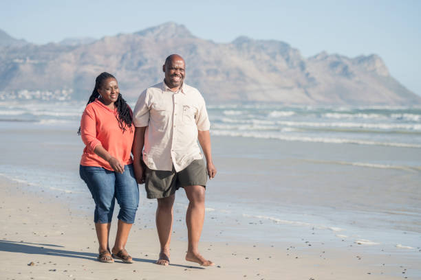 istock Cheerful mature couple on beach with mountains in background 1081917620