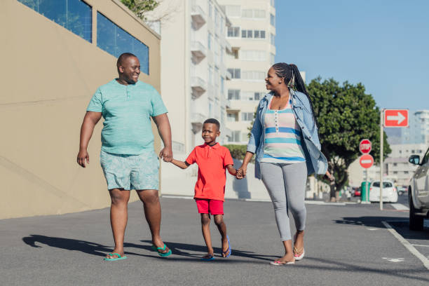 istock Parents and boy holding hands on pavement 1081917622