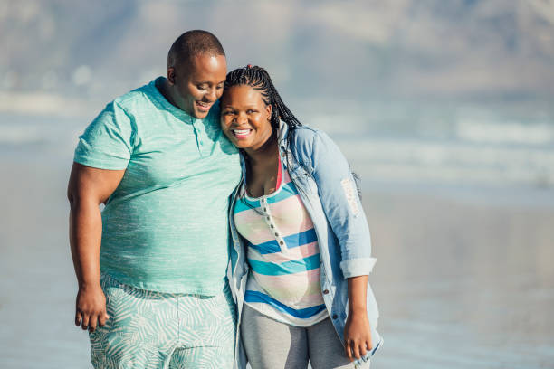 African couple taking romantic walk along beach