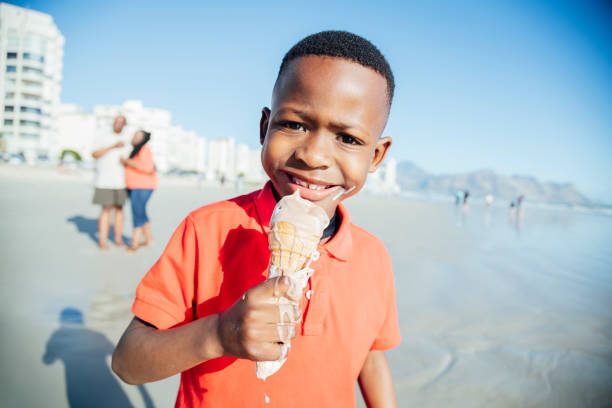 retrato de niño sosteniendo goteo helado y mirando a cámara - ice cream licking little boys ice cream cone fotografías e imágenes de stock