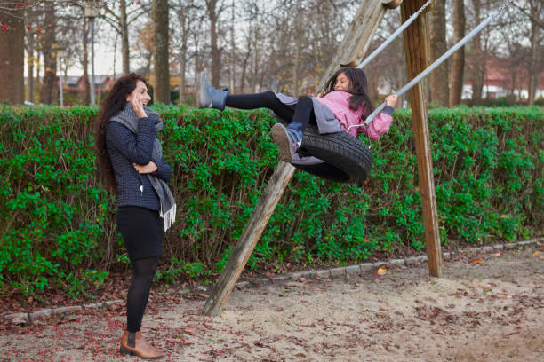 Pakistan immigrants in Denmark. Family living in Horsens, Jutland. Mother watching daughter on the swing.