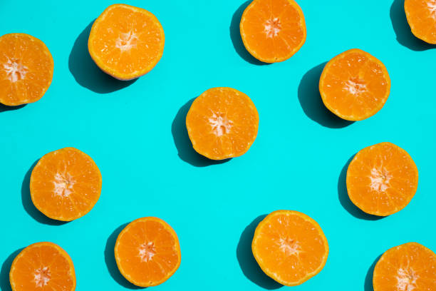 istock Top view fresh orange slices on bright blue background. . Copy Space. creative summer concept. Half of citrus in minimal, Banner 1081923306