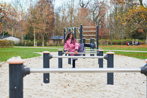 Pakistan immigrants in Denmark. Family living in Horsens, Jutland. Playful daughter, playing on the playground. Incidental people.