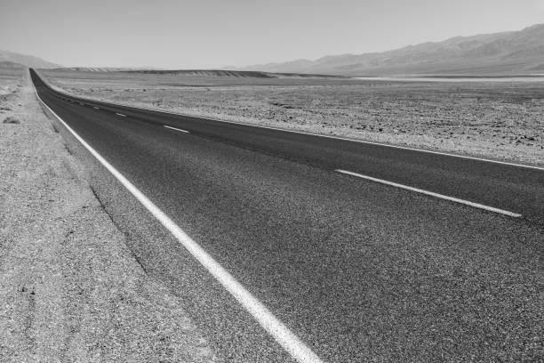 遠くの山々 に砂漠をまっすぐ横切る死の谷道 - desert road road highway california ストックフォトと画像