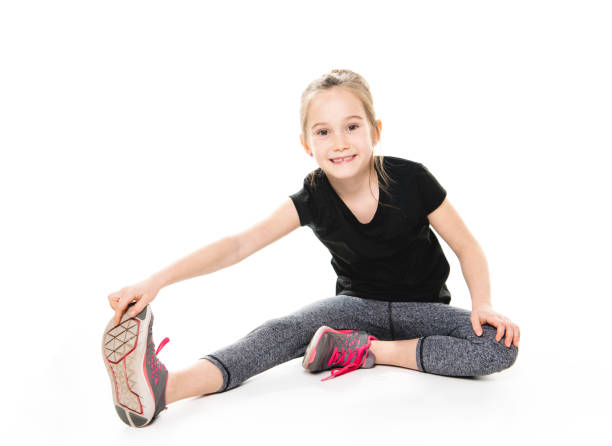 a happy little girl goes in for sports. studio shot isolated on white - gymnastics smiling little girls only isolated on white imagens e fotografias de stock