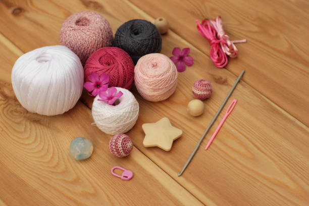 istock crochet pink white grey hooks and yarn, wooden background copy space 1081932484
