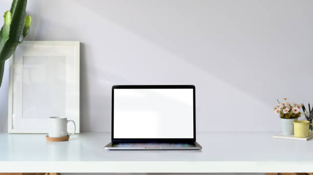 istock Creative workspace. Mockup poster and blank screen laptop on white desk 1081940572