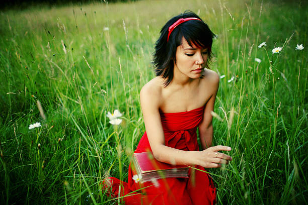 Young woman in a red dress against the lake scenery.