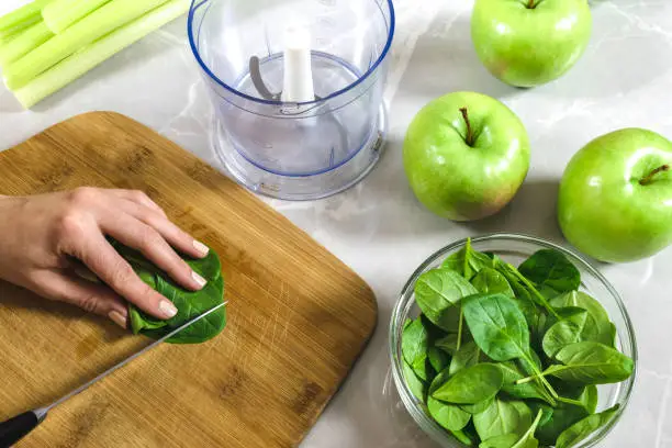 Smoothie preparation from celery, apples and spinach.
