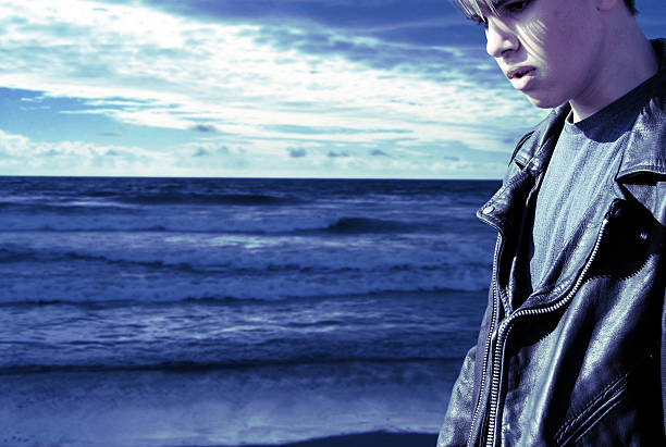 Portrait of Emo Male Teenager Walking Along Beach stock photo