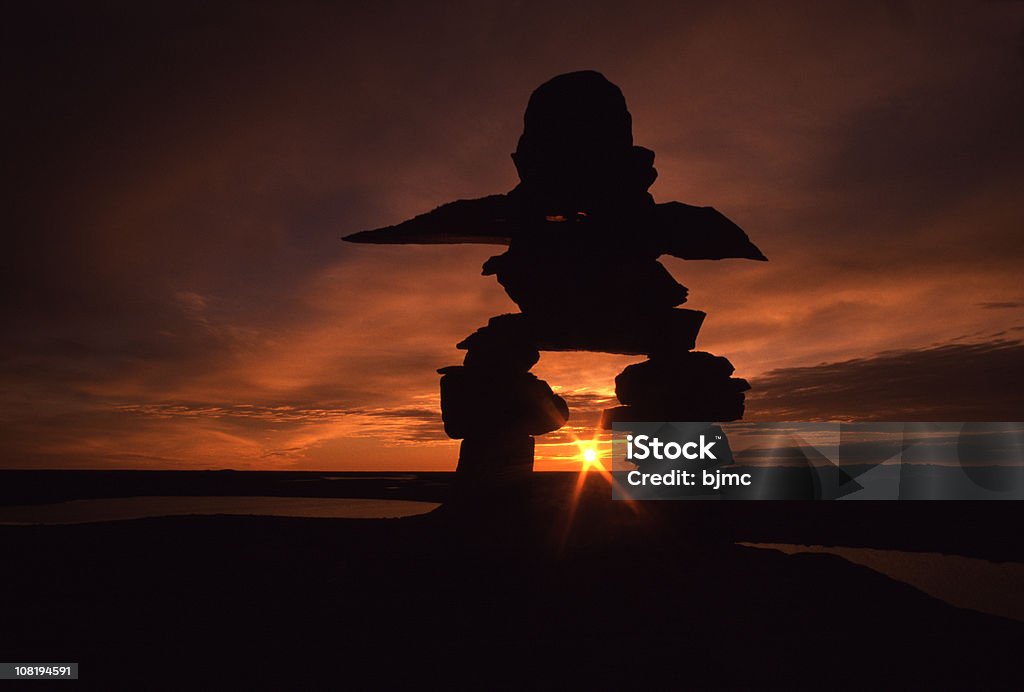 Inuksuk nella terra del sole di mezzanotte (Inukshuk - Foto stock royalty-free di Inukshuk