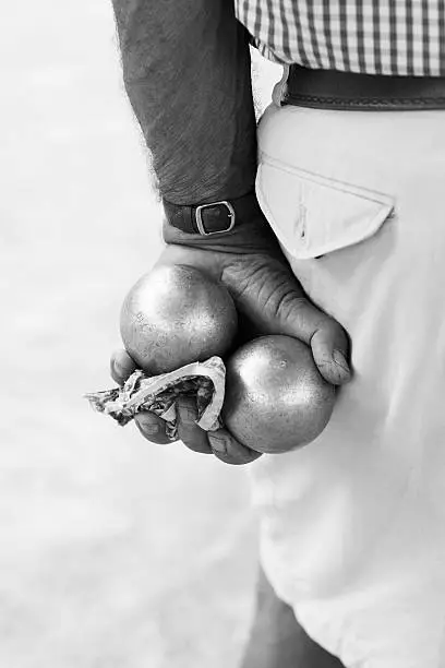 male hand holding boule metal balls