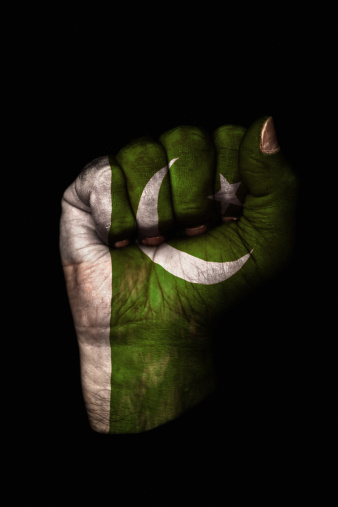 Image of a dirty clenched fist with the flag of Pakistan painted on it.