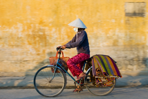 Woman Wearing Traditional Dress in Vietnam Riding Bicycle