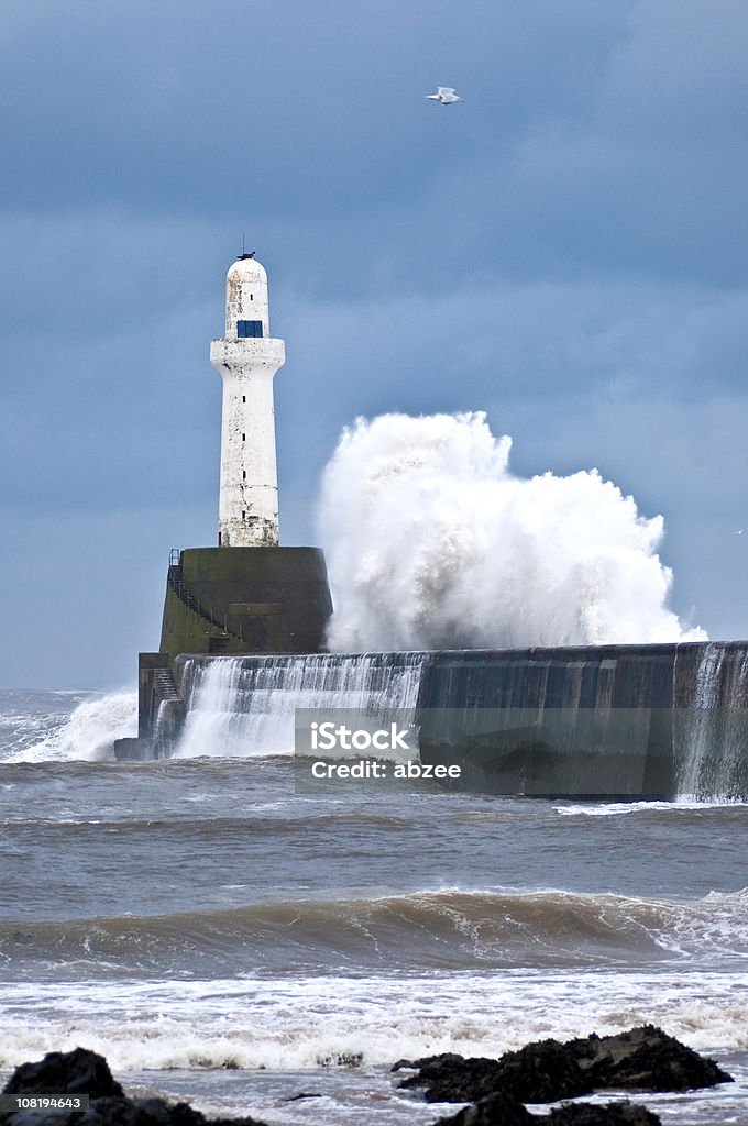 Vagues se brisant sur la digue avec phare dans le port d'Aberdeen - Photo de Aberdeen - Grampian libre de droits