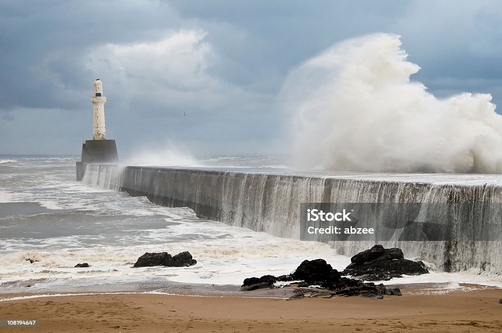 Wellen schlugen auf die Breakwater mit Leuchtturm in Aberdeen Harbour - Lizenzfrei Flut Stock-Foto