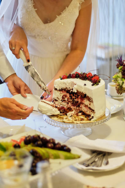 istock Beauty bride and handsome groom are cutting a wedding cake. wedding 1081947626