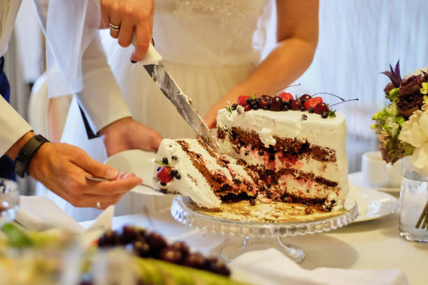 istock Beauty bride and handsome groom are cutting a wedding cake. wedding 1081947638