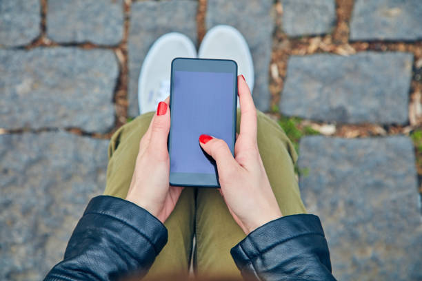 istock Woman sitting on a bench and using smartphone. 1081947960