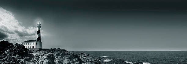 istock Lighthouse on Rocky Coastline with Ocean, Black and White 108194811