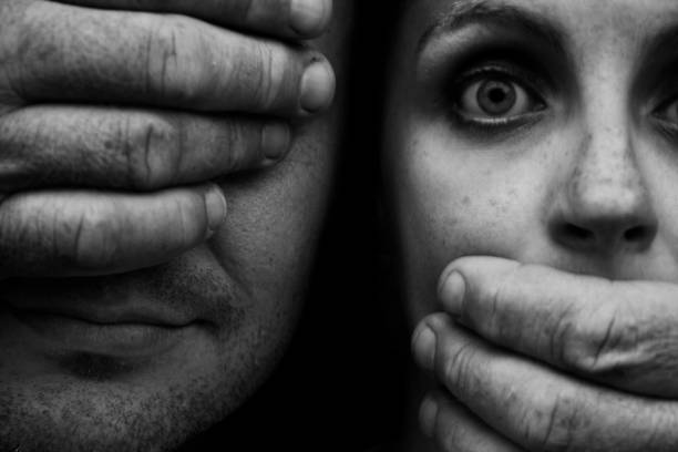 Hands Covering Man's Eye and Startled Woman's Mouth  sexual violence stock pictures, royalty-free photos & images