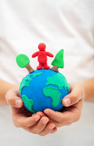 istock Ecology concept with clay world globe in child hand 1081949632