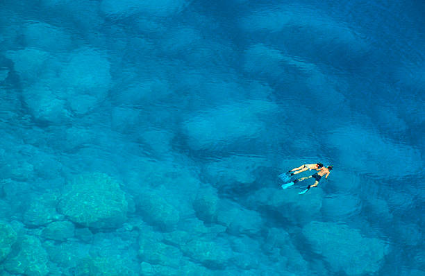 mann und frau schnorcheln im blauen mittelmeer - sea high angle view water tranquil scene stock-fotos und bilder