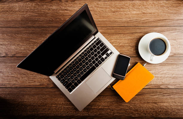 istock Office desk with laptop computer, planner, mobile smartphone and coffee cup. 1081950340
