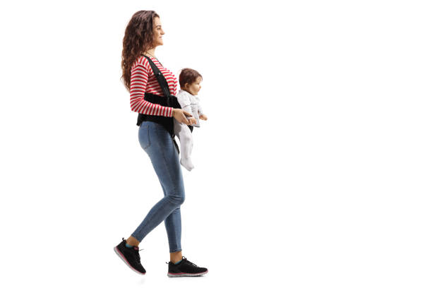 istock Young mother with a baby in a carrier walking 1081950720