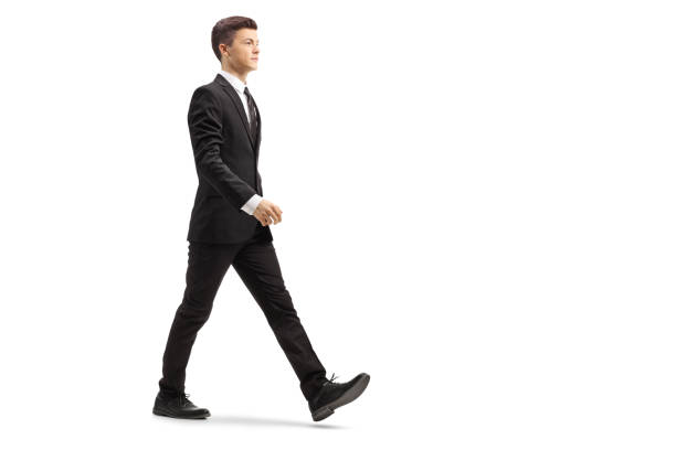 istock Young handsome man in a black suit walking 1081950920